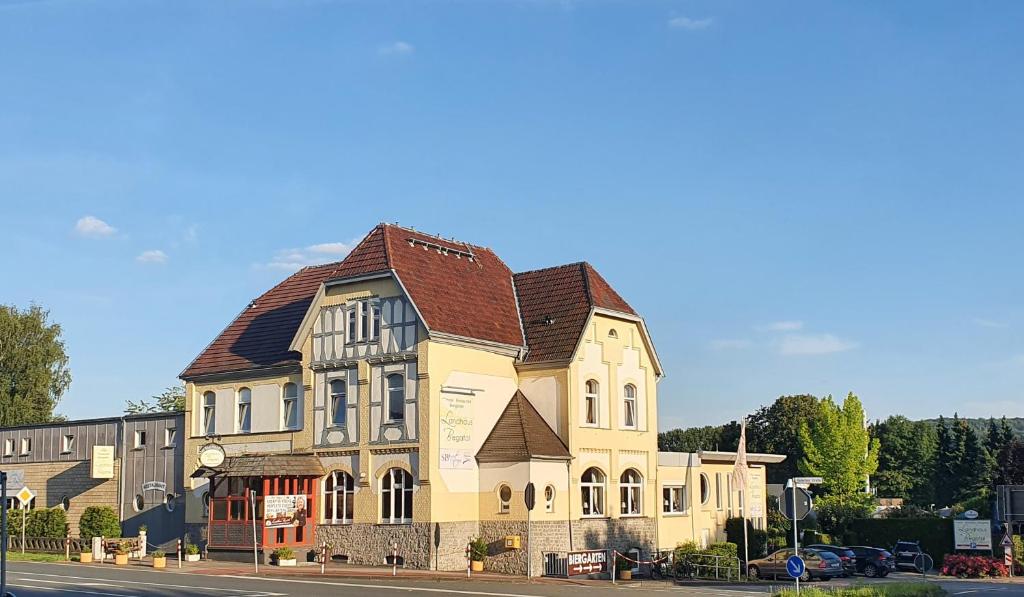 ein großes gelbes Gebäude mit braunem Dach in der Unterkunft Landhaus Begatal in Dörentrup