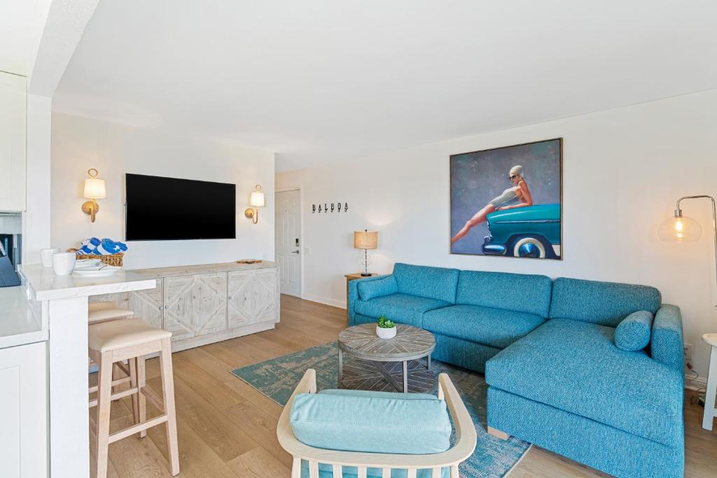 a living room with a blue couch and a tv at Palm Tree Oasis in Newport Beach