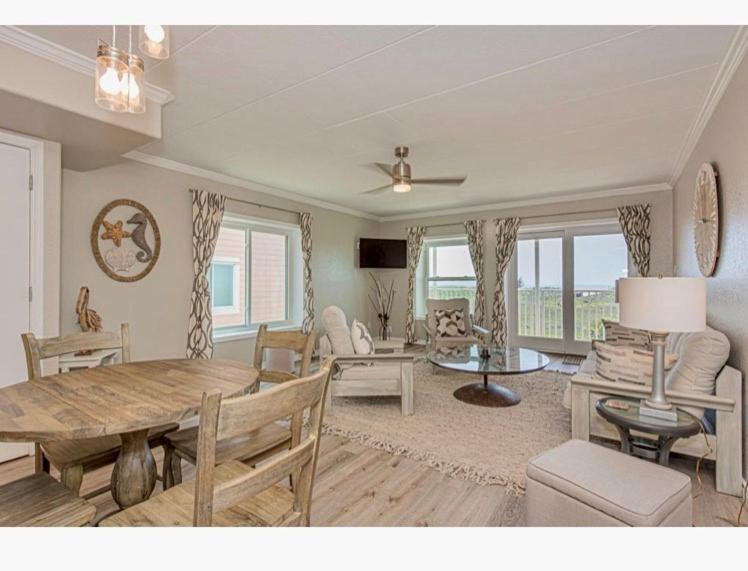 a living room with a table and a dining room at IR145 2nd Floor Condo, Ocean View, 1 Bedroom, Shared Pools, Boardwalks in Port Aransas