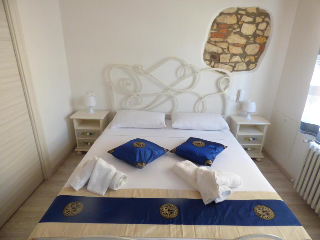 Schlafzimmer mit einem Bett mit blauen und weißen Kissen in der Unterkunft NICOLE DONEY LOCAZIONE TURISTICA in Verona