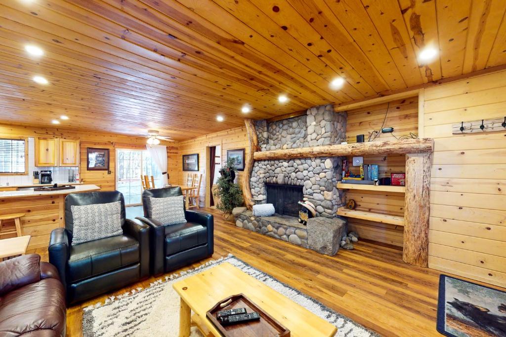a living room with a stone fireplace in a cabin at River Rock Lodge in South Lake Tahoe