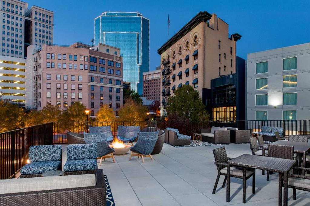 a rooftop patio with chairs and tables and buildings at Fairfield Inn & Suites Fort Worth Downtown/Convention Center in Fort Worth