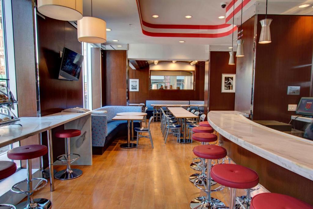 un bar en un restaurante con taburetes rojos en Fairfield Inn by Marriott New York Manhattan/Financial District, en Nueva York