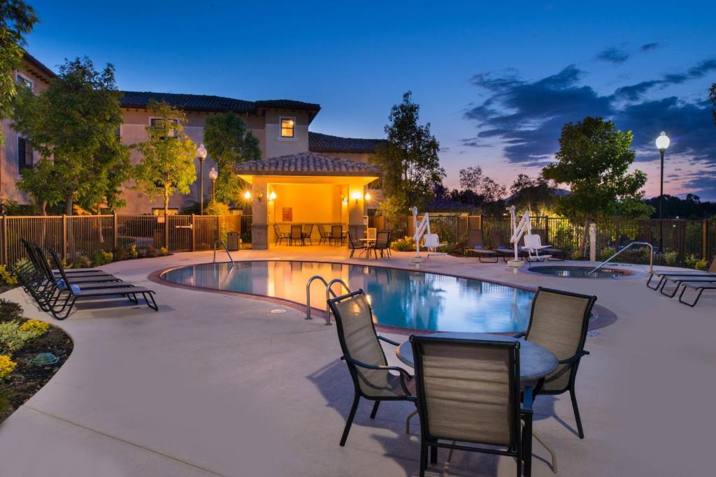 un patio con sedie e una piscina di notte di TownePlace Suites Thousand Oaks Ventura County a Thousand Oaks