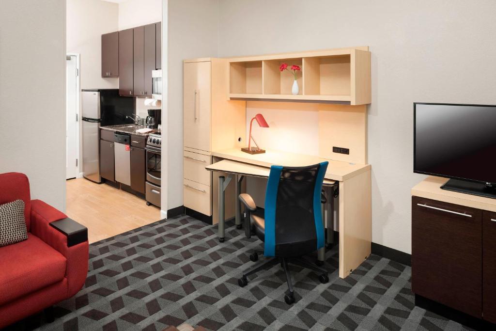 una pequeña oficina con escritorio y silla roja en TownePlace Suites Columbus, en Columbus