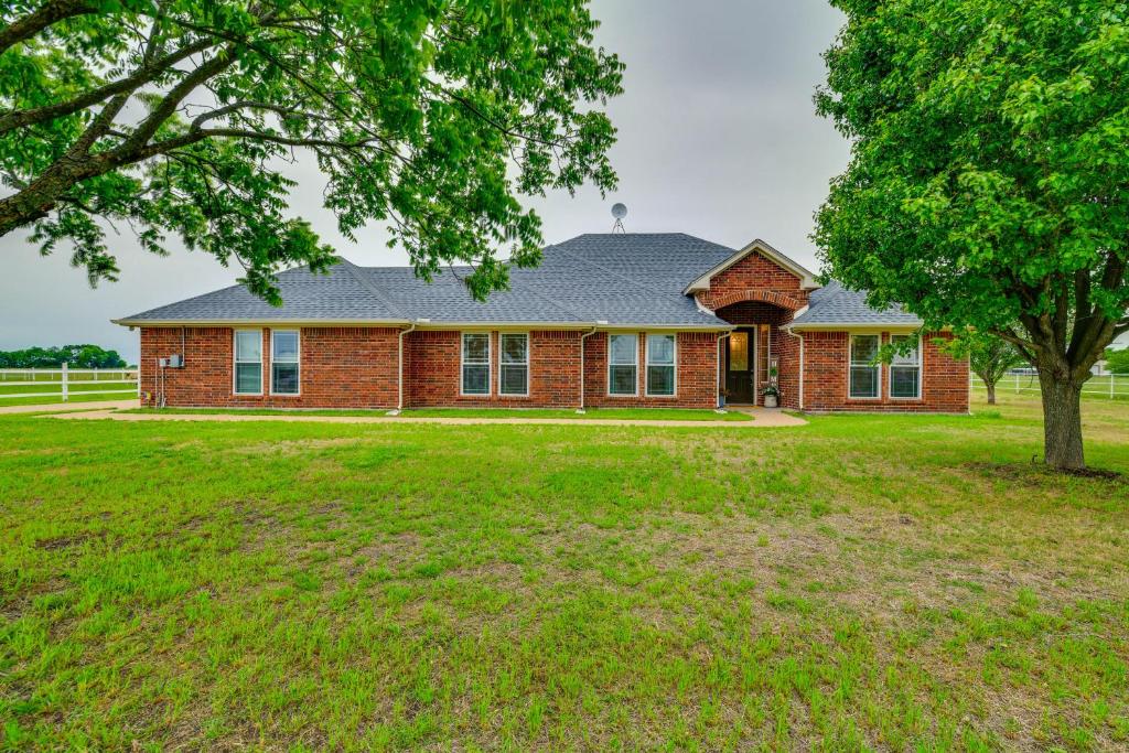 een rood bakstenen huis met een boom ervoor bij Pet-Friendly Waxahachie Vacation Home with Backyard! in Waxahachie