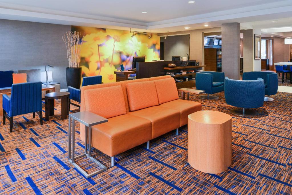 a lobby with a couch and tables and chairs at Courtyard Beaumont in Beaumont