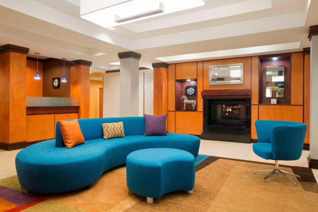sala de estar con sofá azul y 2 sillas en Fairfield Inn & Suites Columbia Northeast, en Columbia