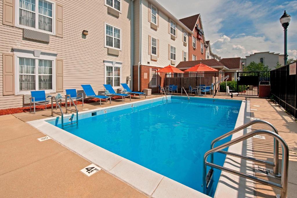 a swimming pool with blue chairs and a building at TownePlace Suites by Marriott Bloomington in Bloomington
