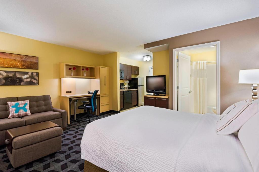 um quarto de hotel com uma cama e um sofá em TownePlace Suites Pensacola em Pensacola