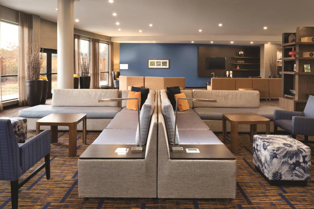 eine Hotellobby mit Sofas, Tischen und Stühlen in der Unterkunft Courtyard by Marriott Salisbury in Salisbury