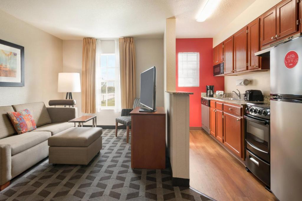 a living room with a couch and a kitchen at TownePlace Suites Fort Lauderdale West in Fort Lauderdale