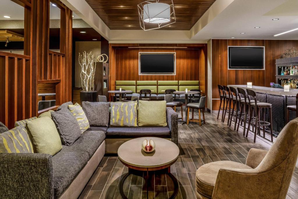 a living room with couches and a bar at Courtyard Charlotte City Center in Charlotte