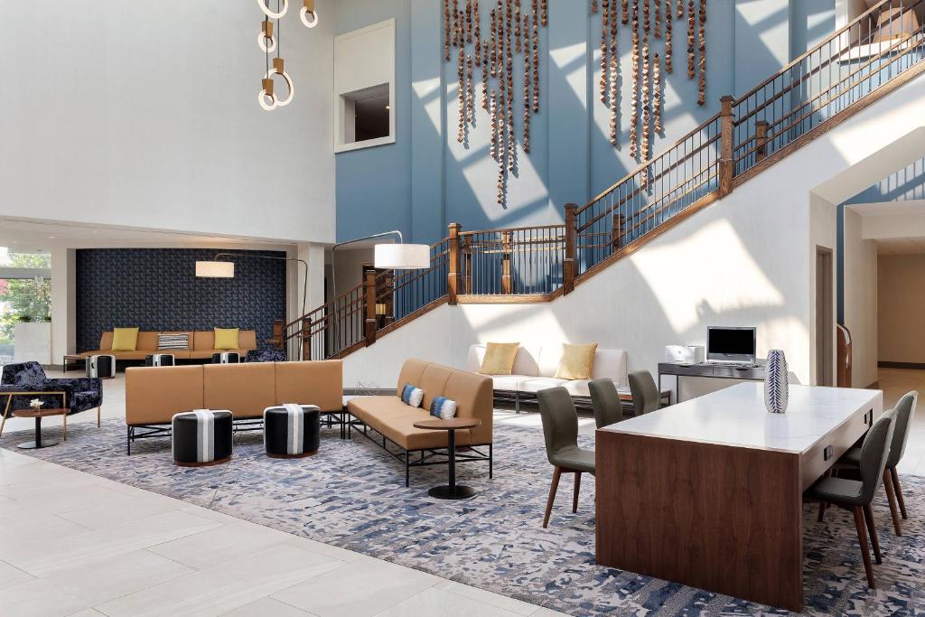 hol z krzesłami i stołami oraz klatką schodową w obiekcie Delta Hotels by Marriott Woodbridge w mieście Iselin