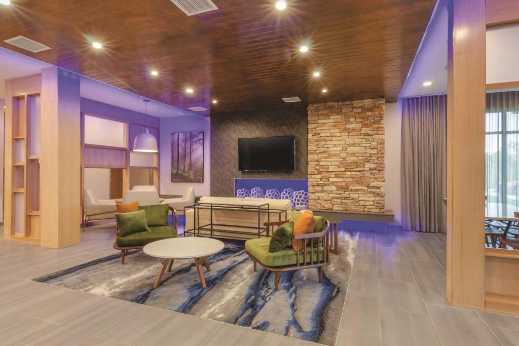 a lobby with chairs and a table and a tv at Fairfield Inn & Suites by Marriott Kansas City Shawnee in Shawnee