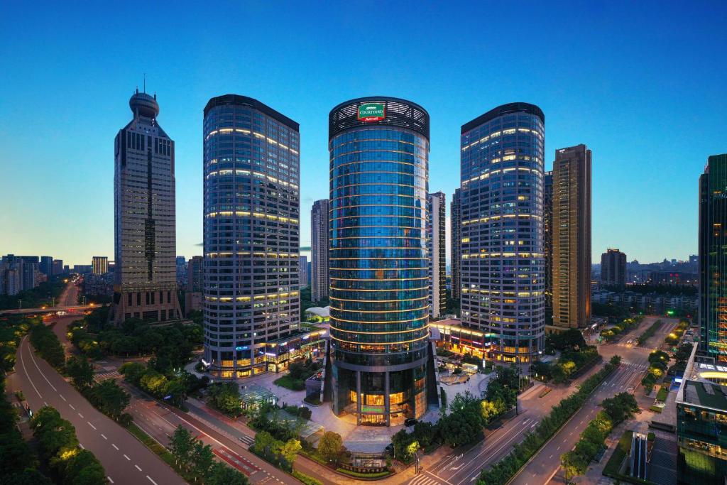 un gruppo di edifici alti in una città di Courtyard by Marriott Hangzhou Qianjiang a Hangzhou
