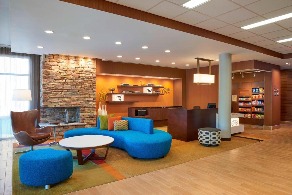 a lobby of a library with blue furniture and a fireplace at Fairfield by Marriott Niagara Falls in Niagara Falls