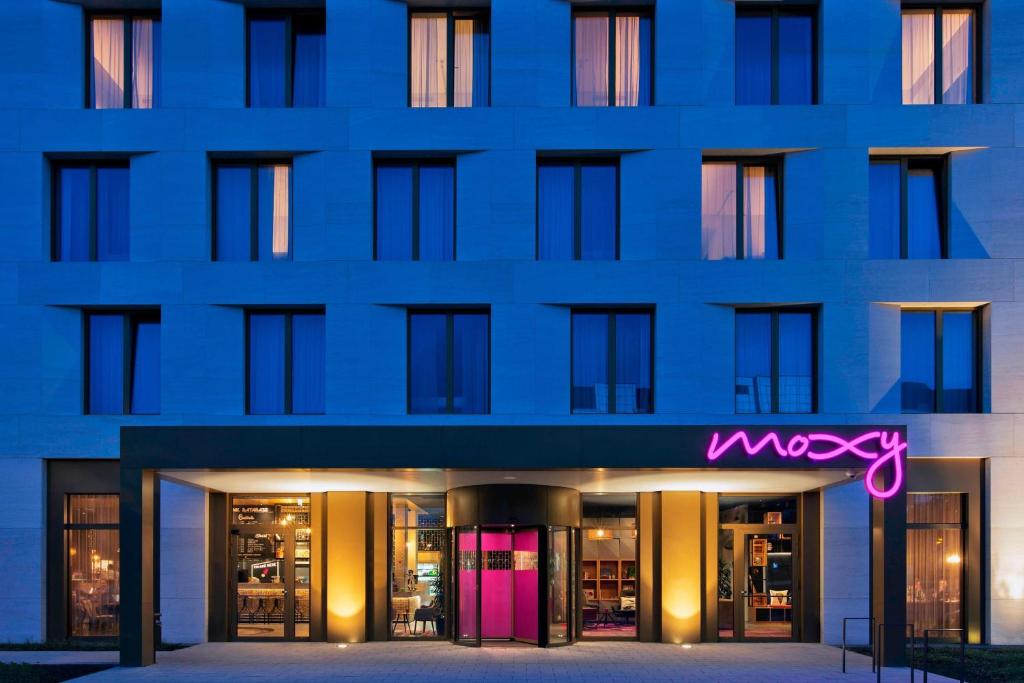 a building with a neon sign in front of it at Moxy Darmstadt in Darmstadt