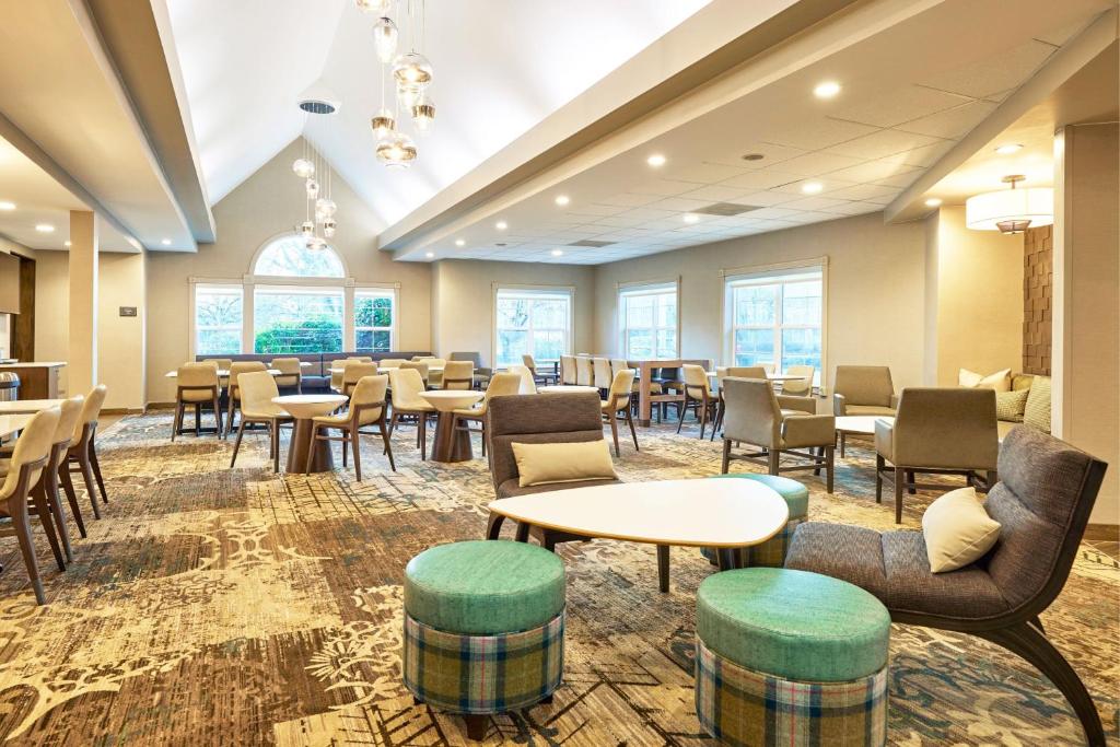 a waiting room with tables and chairs and windows at Residence Inn Eugene Springfield in Eugene