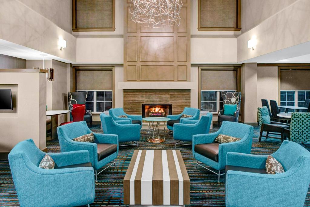 hol z niebieskimi krzesłami i kominkiem w obiekcie Residence Inn by Marriott Cleveland Beachwood w mieście Beachwood