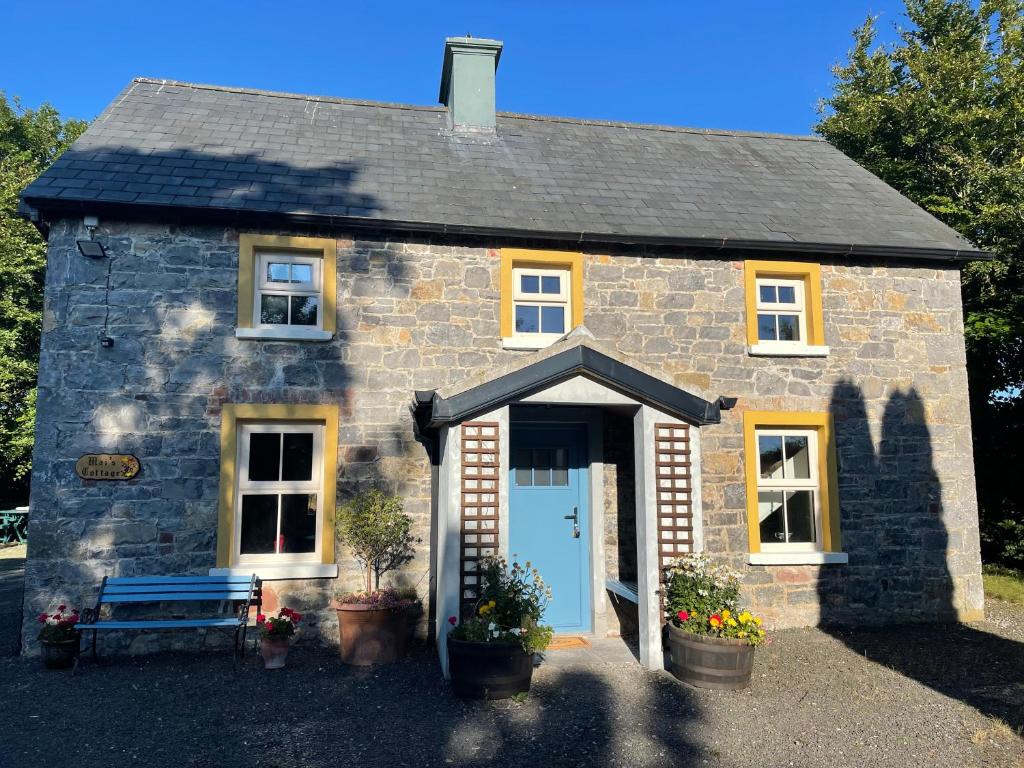 ein kleines Steinhaus mit blauer Tür in der Unterkunft Mai's Cottage Suite - Charming Holiday Rental in Kilmallock