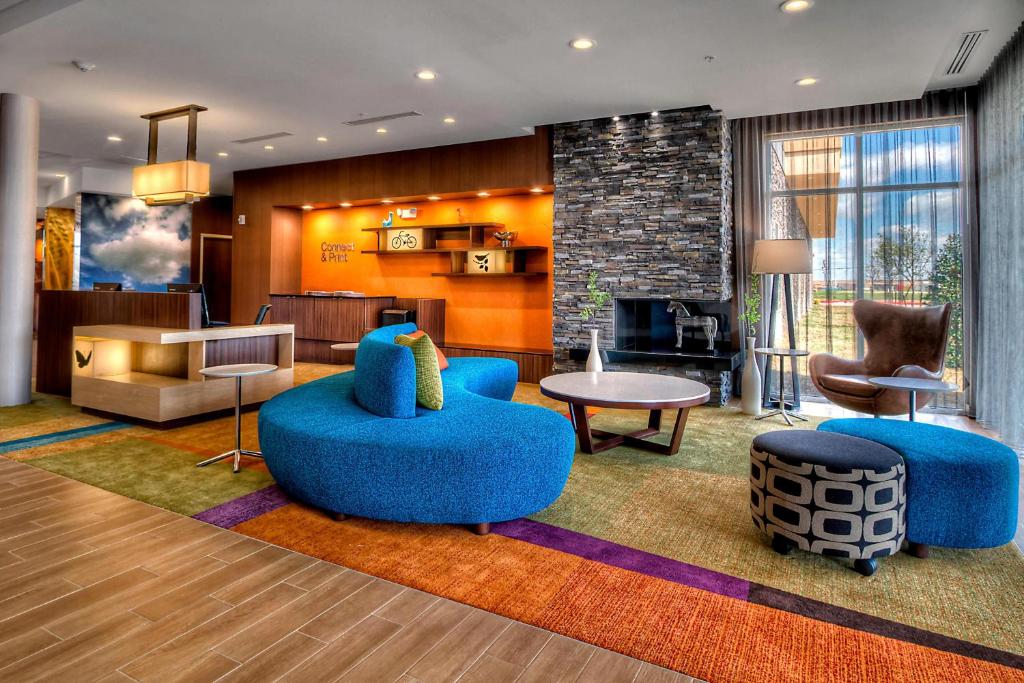 a lobby with blue chairs and a living room at Fairfield Inn and Suites Oklahoma City Yukon in Yukon