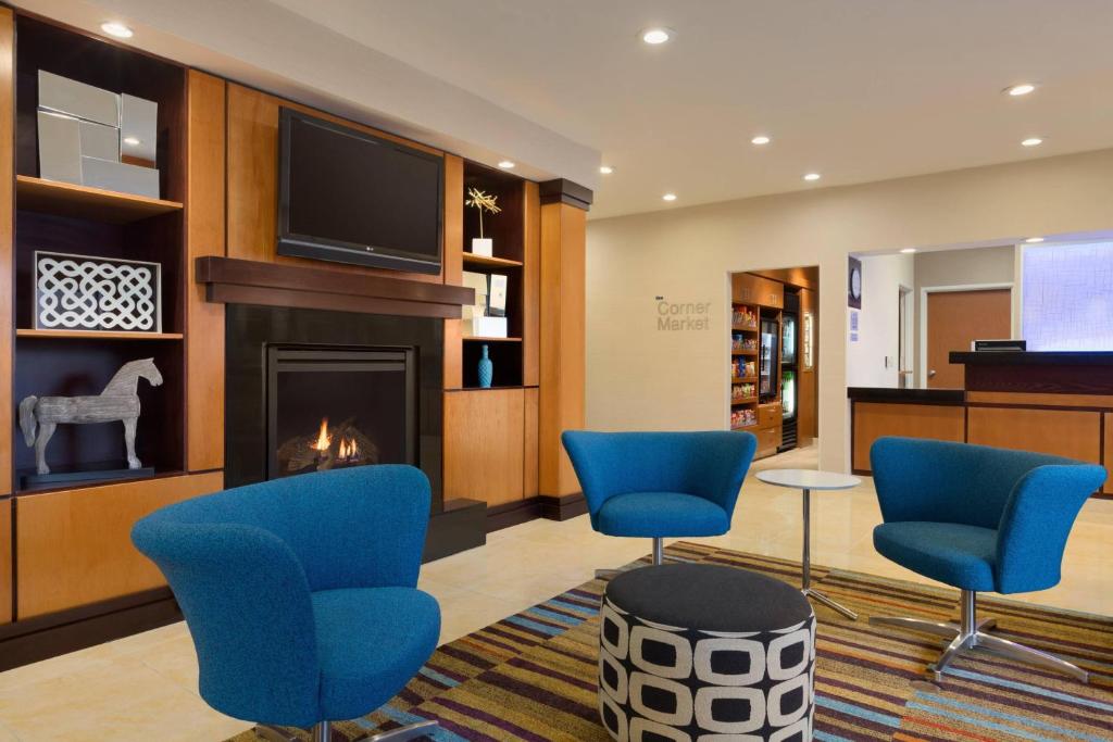 eine Lobby mit blauen Stühlen und einem Kamin in der Unterkunft Fairfield Inn & Suites Bismarck North in Bismarck