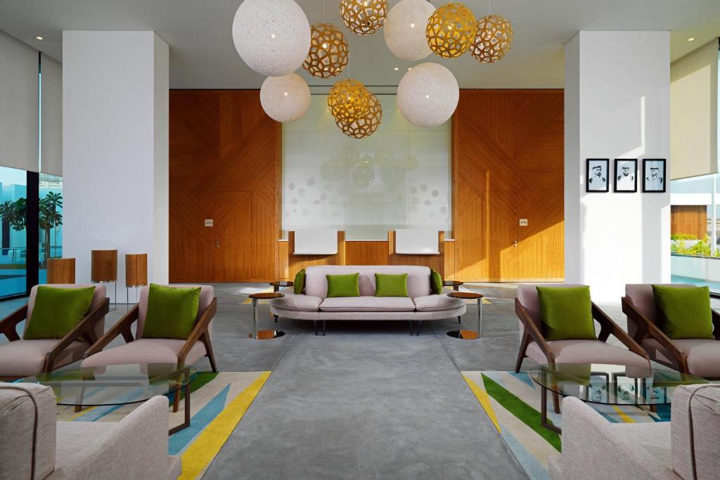 a lobby with a couch and chairs and lights at Element Me'aisam, Dubai in Dubai
