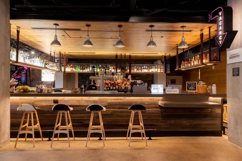 a bar with three stools at a counter at Moxy Nashville Downtown in Nashville