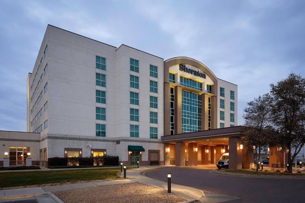 Sheraton Sioux Falls & Convention Center في شلالات سيوكس: مبنى أبيض كبير مع سيارة متوقفة أمامه