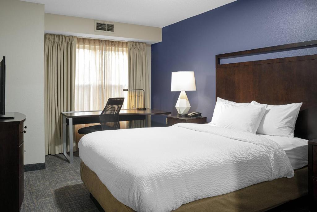 a hotel room with a large bed and a desk at Residence Inn Boston Foxborough in Foxborough