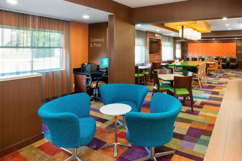 a waiting room with blue chairs and tables at Fairfield Inn & Suites Chicago Tinley Park in Tinley Park