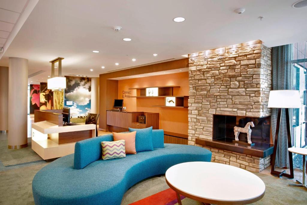 a living room with a blue couch and a fireplace at Fairfield Inn & Suites by Marriott Phoenix Tempe/Airport in Tempe