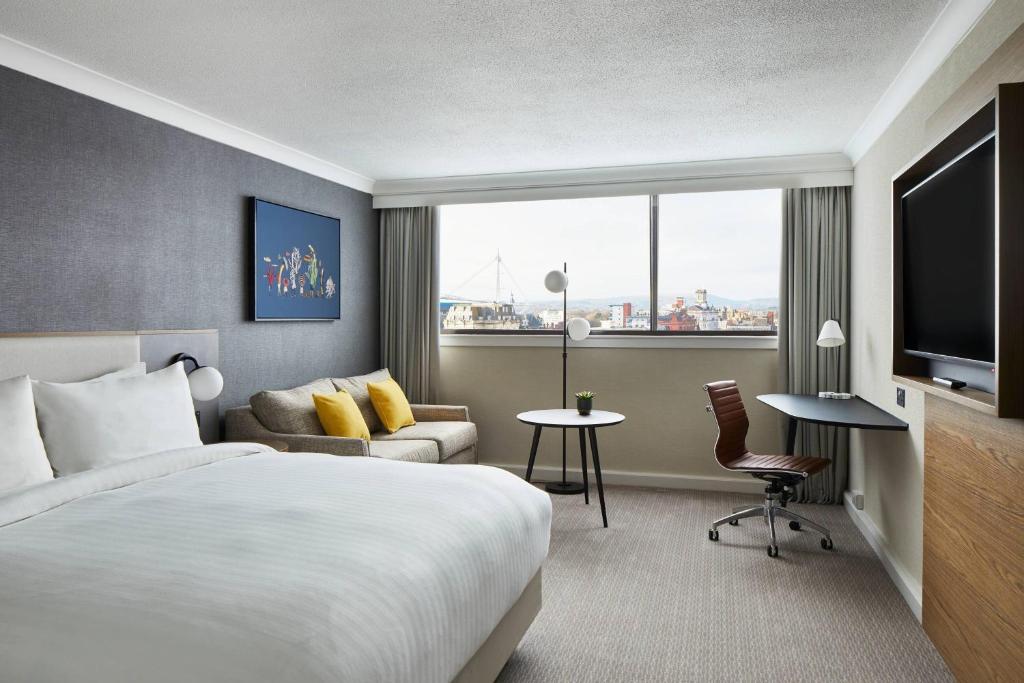 a hotel room with a bed and a large window at Cardiff Marriott Hotel in Cardiff