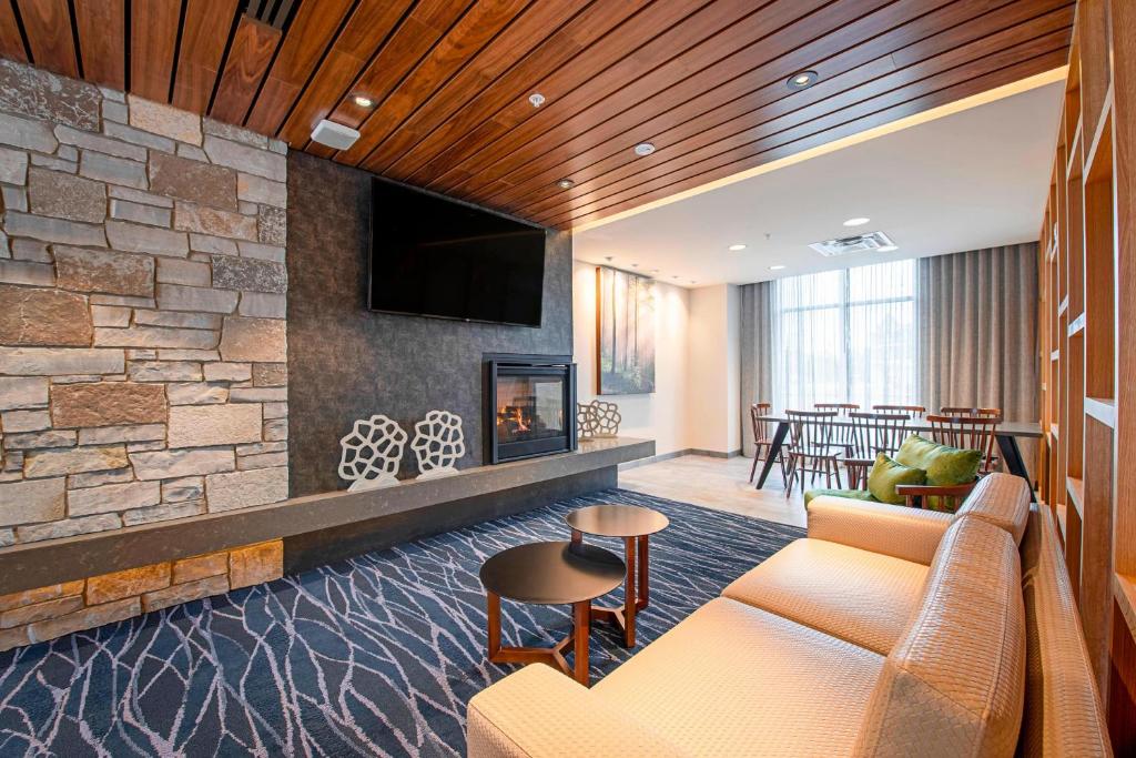 Fairfield Inn & Suites By Marriott Duluth Waterfront في دولوث: غرفة معيشة مع موقد وتلفزيون