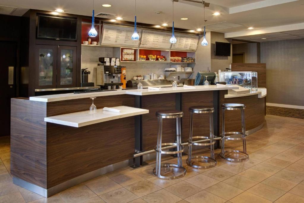 a kitchen with a counter with bar stools at Courtyard by Marriott Kokomo in Kokomo