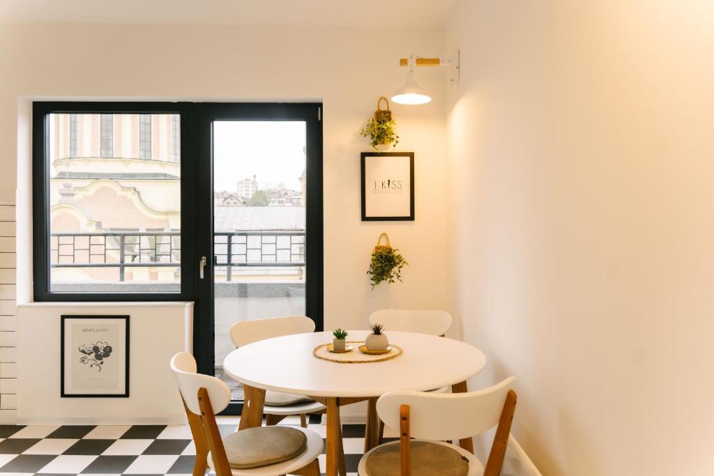 a table and chairs in a room with a window at Sarajevo Skyline Apartment in Sarajevo