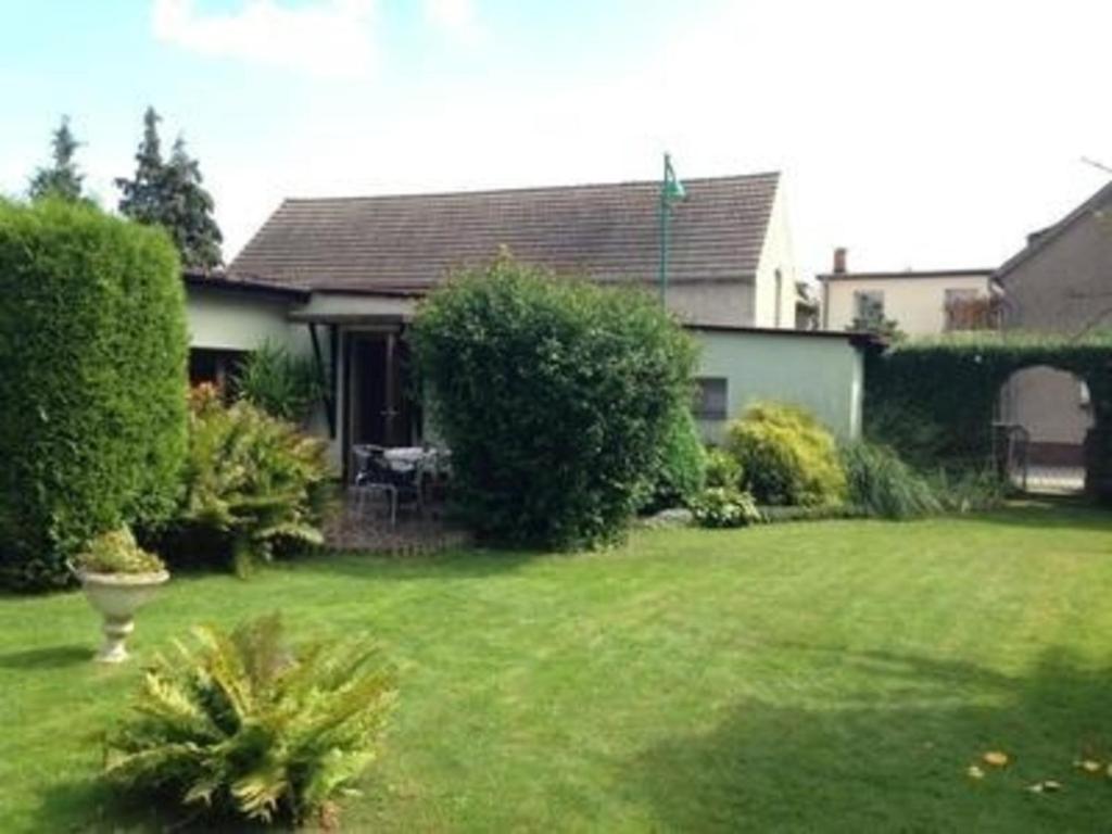 a house with a yard with a green lawn at Tolles Appartement in Gehren mit Garten, Terrasse und Grill in Heideblick