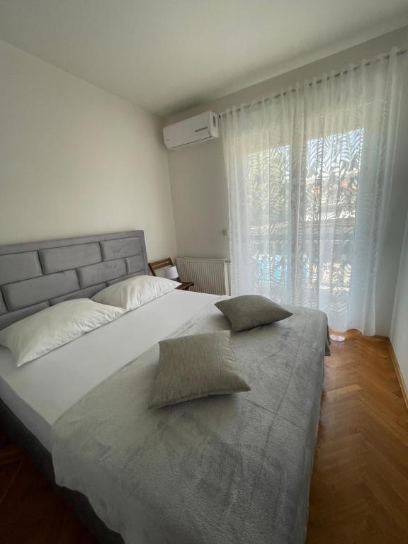 a bedroom with a large bed with a large window at Apartments Vip in Split