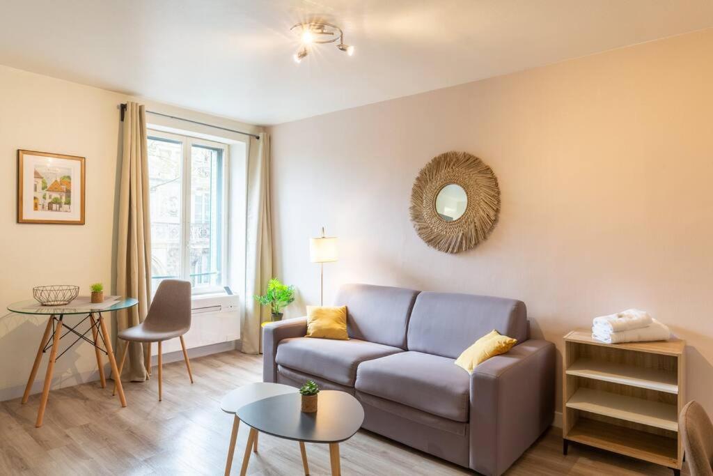 salon z kanapą i stołem w obiekcie Elégants studios, proches de la place Wilson w mieście Dijon