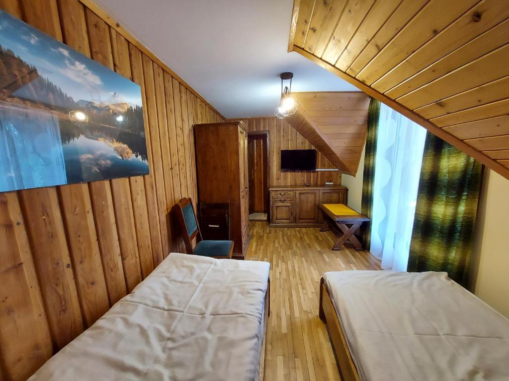 - une petite chambre avec 2 lits et un escalier dans l'établissement Sokoli Dwór, à Smardzewice