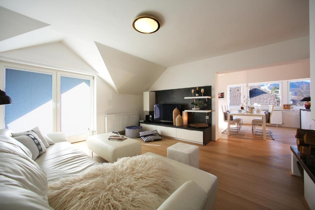De luxe Apartment GOLOB Kranjska Gora في كراجسكا غورا: غرفة معيشة مع أريكة بيضاء وطاولة