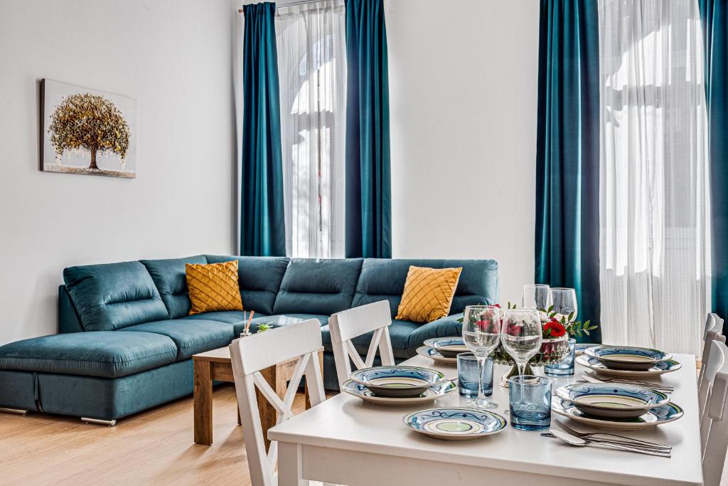 a living room with a table and a blue couch at ARI Central Apartment 2 in Arad