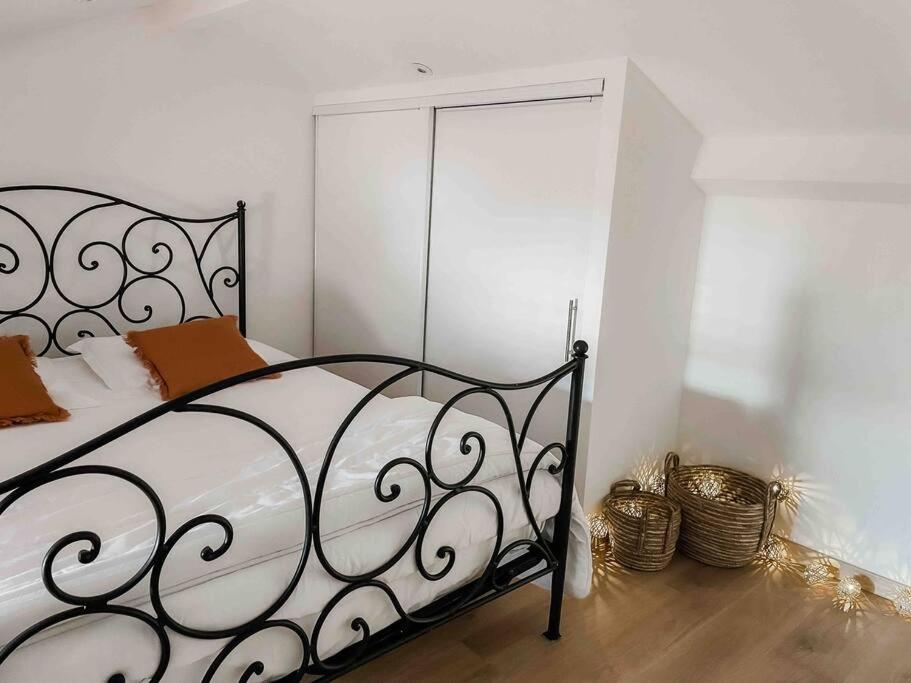 een slaapkamer met een zwart metalen bed en een spiegel bij SanCiprianu à 5minutes de la plage in Lecci
