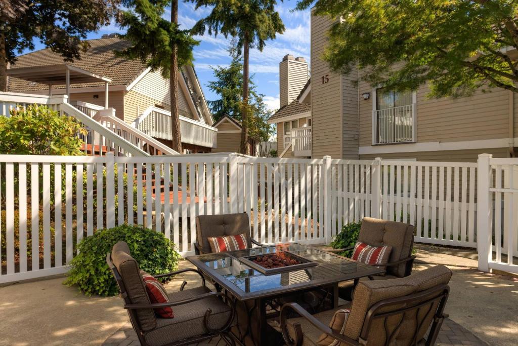 een patio met een tafel en stoelen en een hek bij Residence Inn by Marriott Seattle/Bellevue in Bellevue