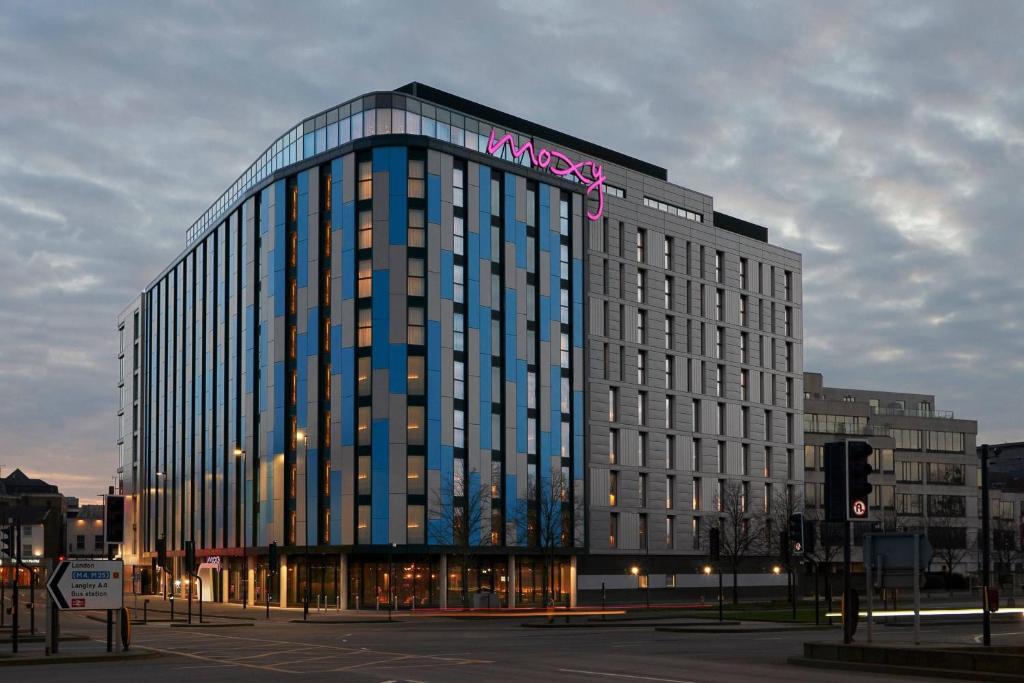 a large building with a sign on top of it at Moxy Slough in Slough