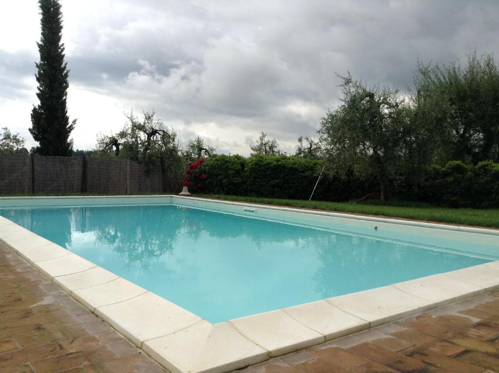 una piscina de agua azul en un patio en Il Glicine 3, en San Gimignano