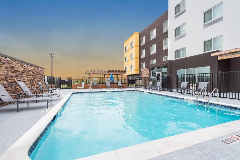 uma grande piscina com cadeiras e um edifício em Fairfield Inn & Suites by Marriott Corpus Christi Aransas Pass em Aransas Pass