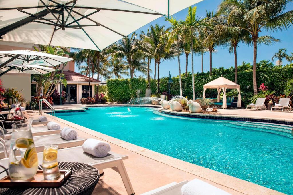 una piscina con palmeras en un complejo en Renaissance Fort Lauderdale Cruise Port Hotel en Fort Lauderdale