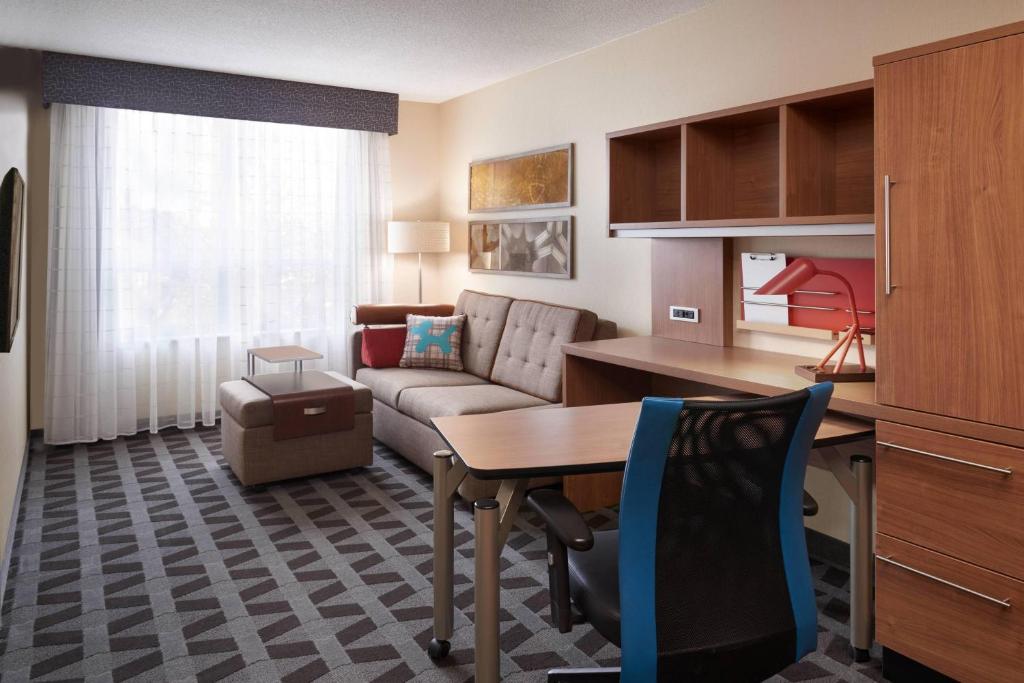 a living room with a couch and a table at TownePlace Suites by Marriott Windsor in Windsor